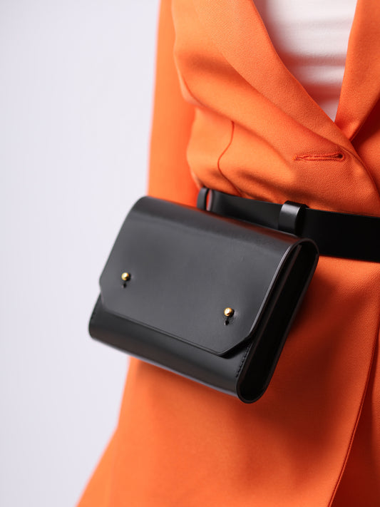 Detailed view of black envelope belt bag.