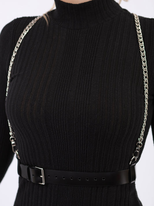 Detailed view of black leather chain harness.
