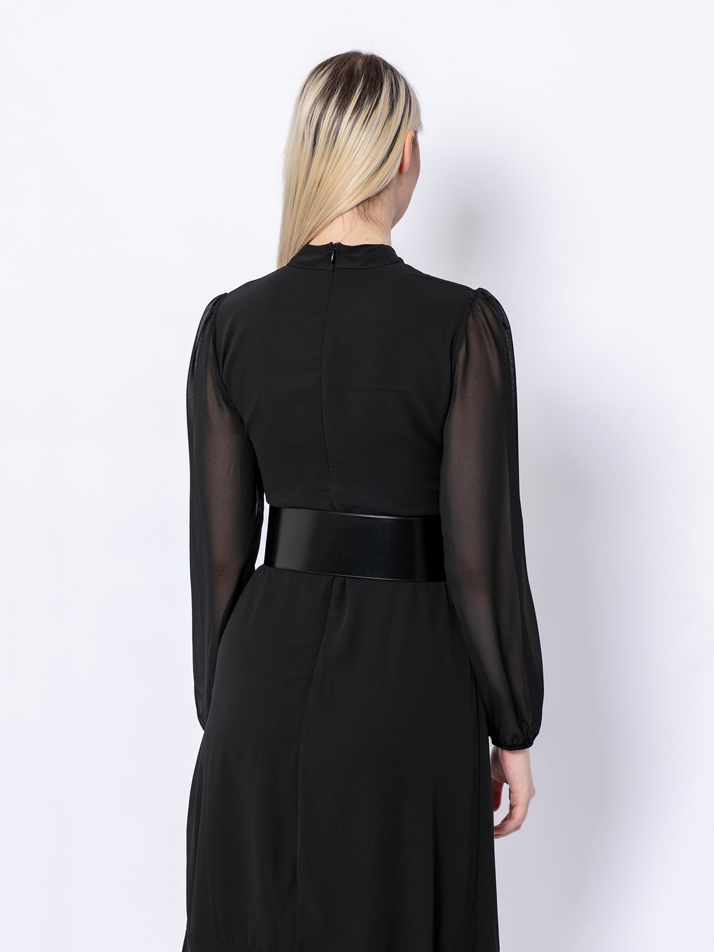 Back view of wide corset belt worn by model over black dress.