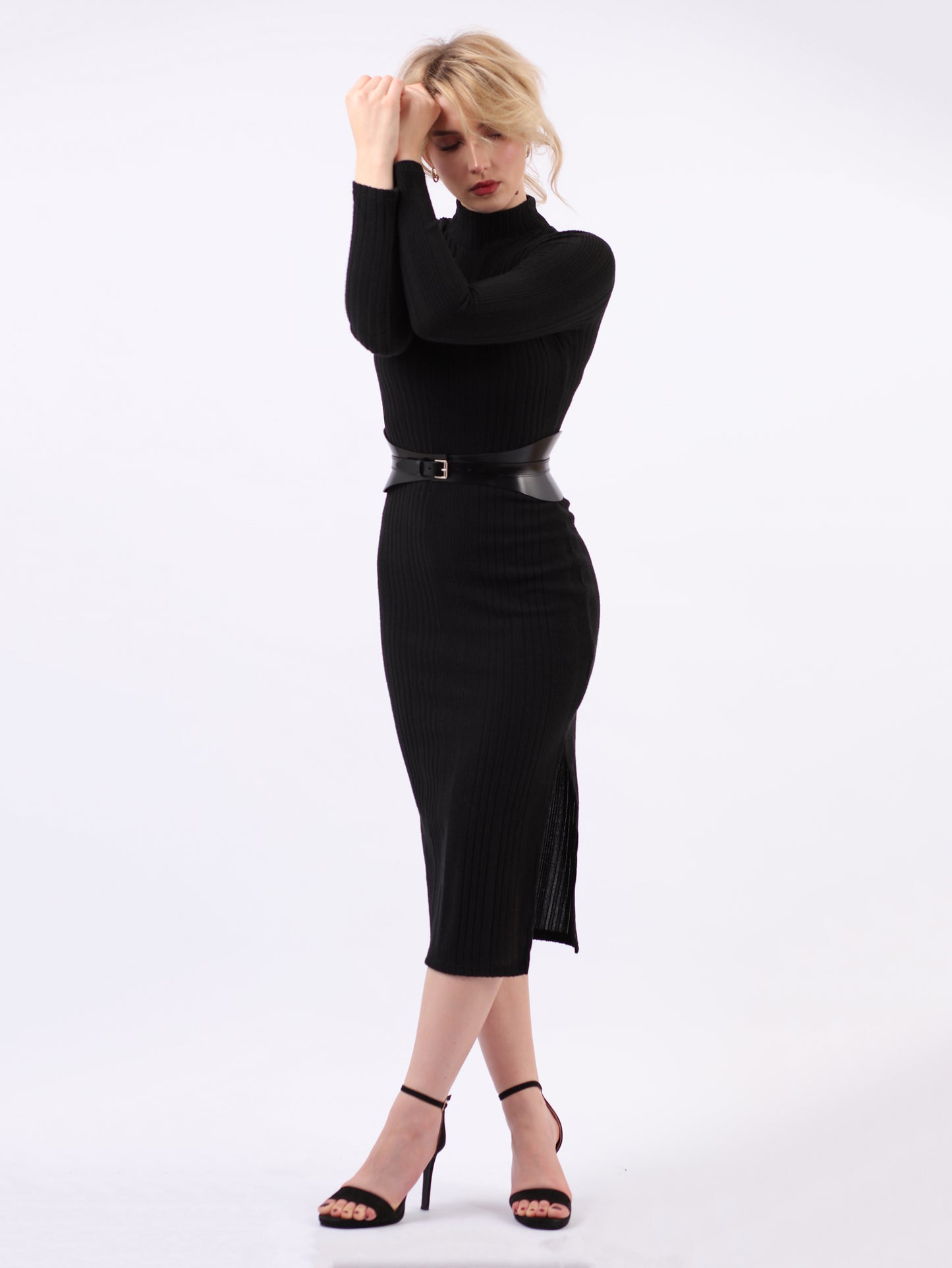 Black leather corset belt fitted on woman wearing black dress.
