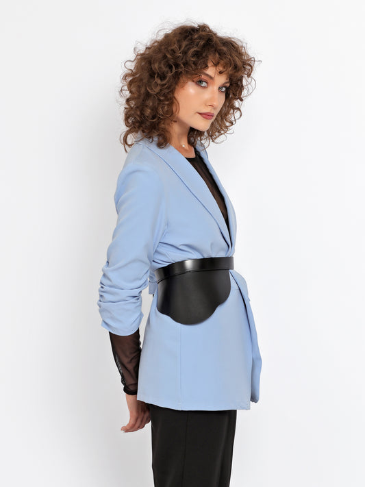 Side view of black leather waist belt being worn over blue blazer.