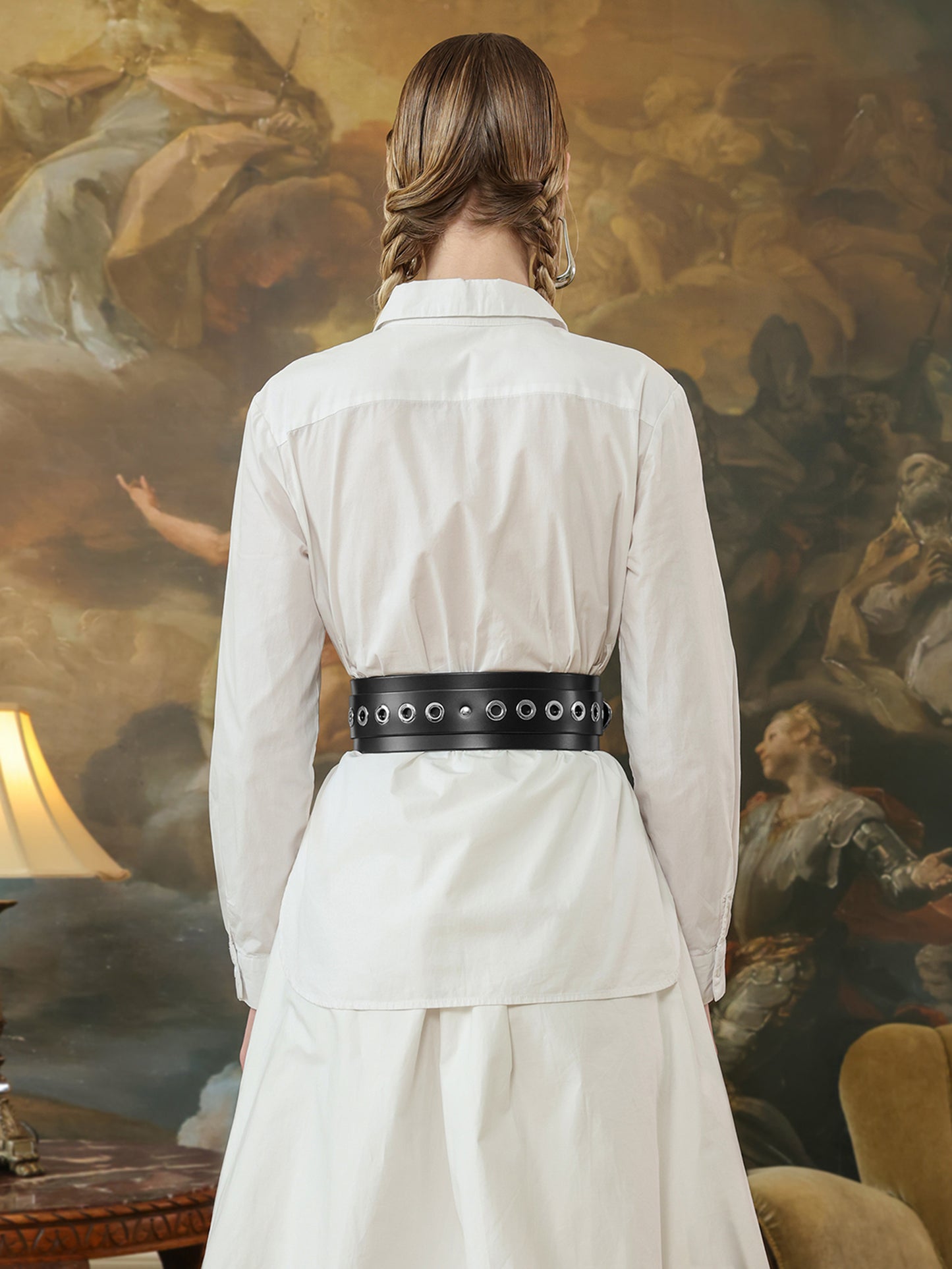 Back view of wide black grommet belt over a white dress.