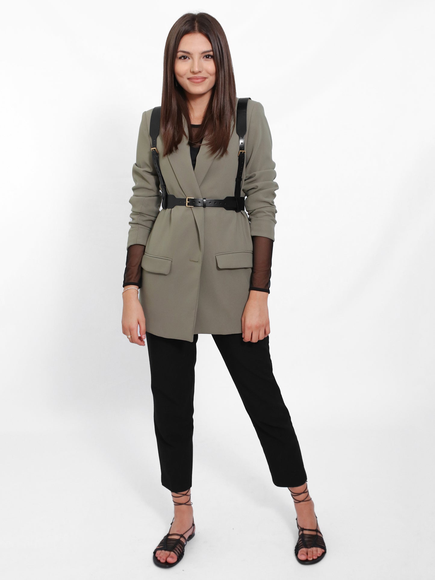 Casual outfit where the black leather suspender harness is worn with green blazer and black pants.