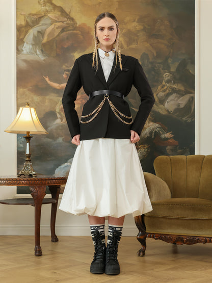 Black leather chain belt styled with black blazer and white skirt for women.