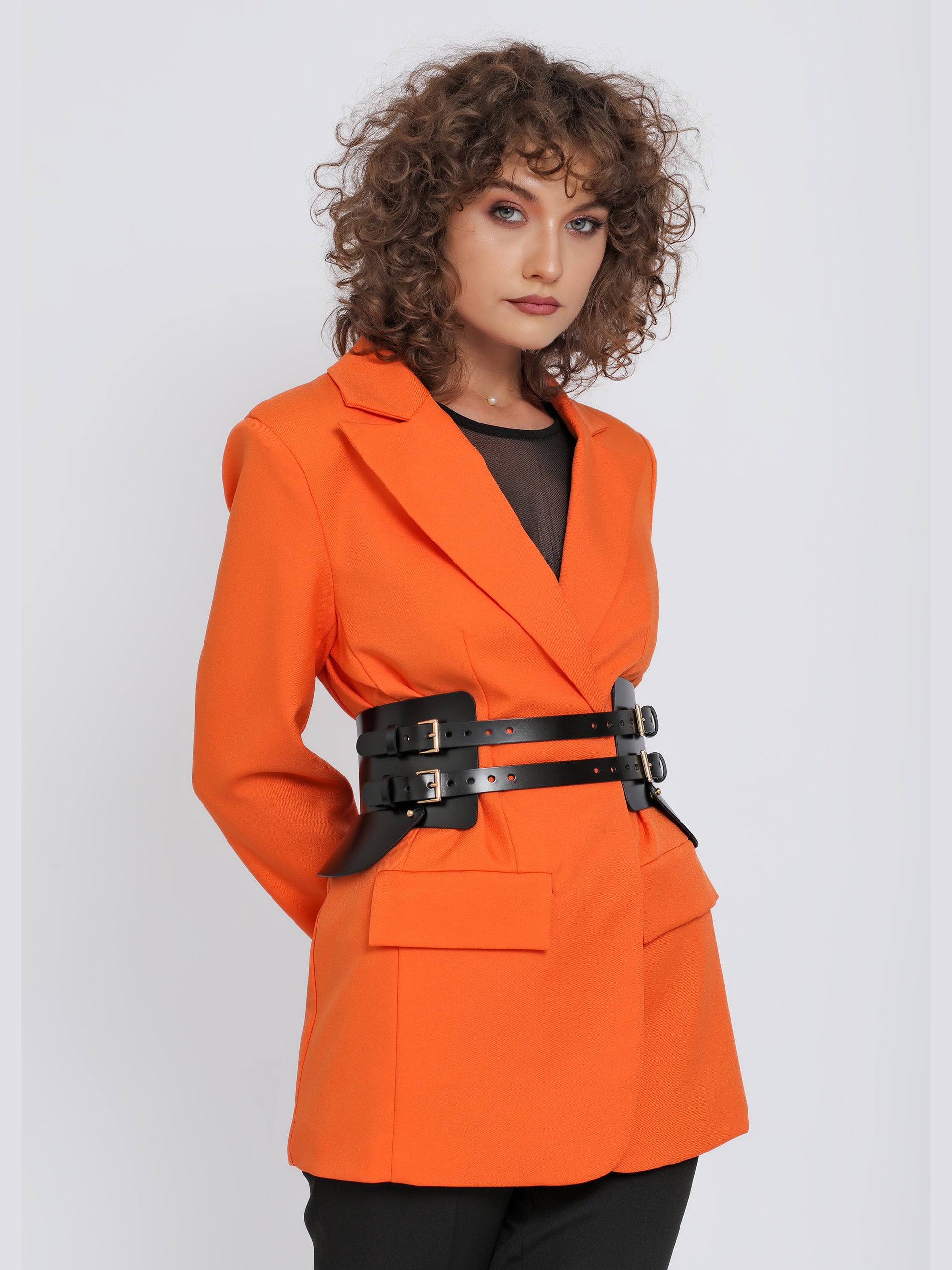 Front view of black leather wide belt being worn over orange blazer.