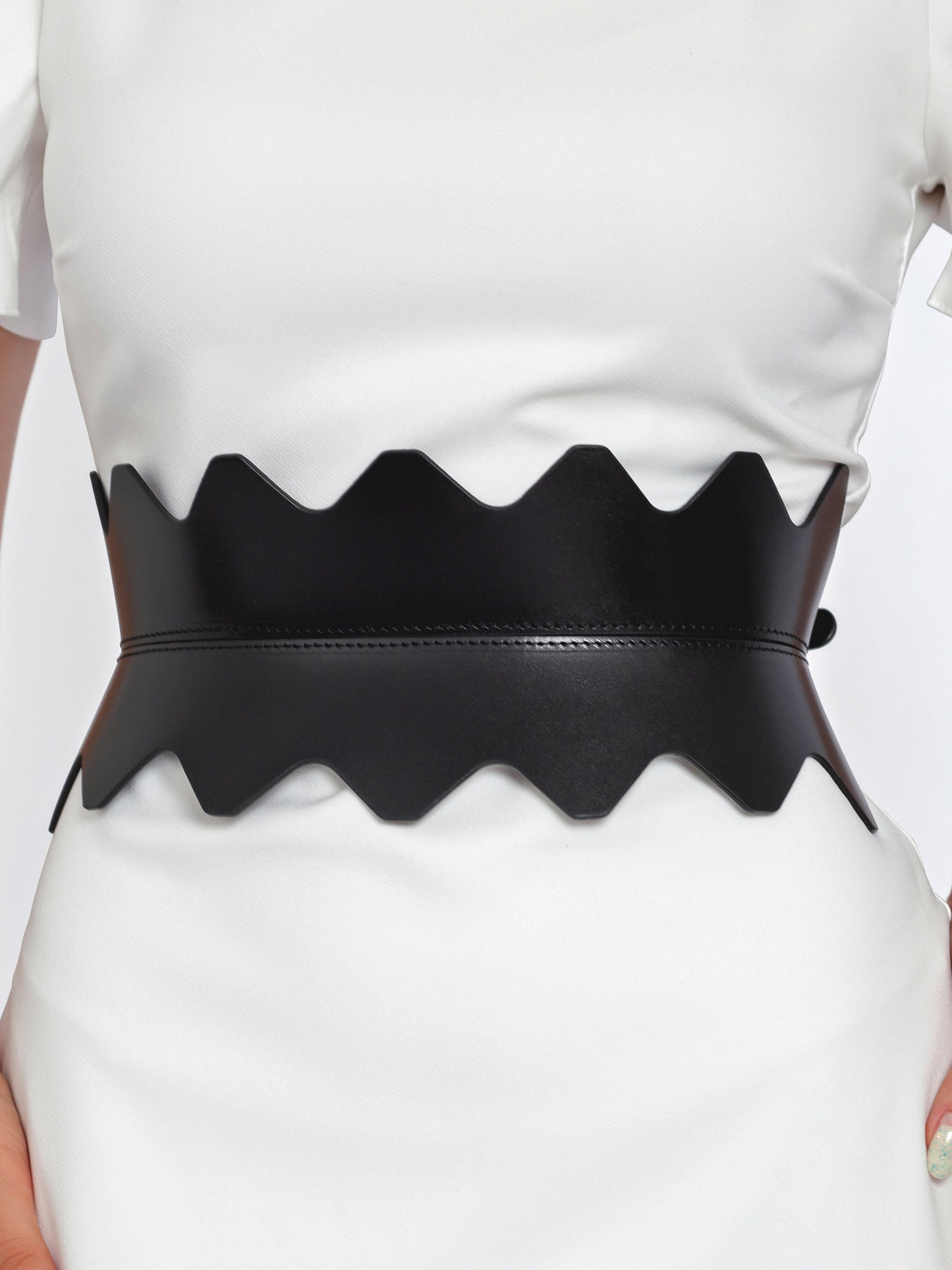 Close view of black hourglass corset belt being worn over white dress.