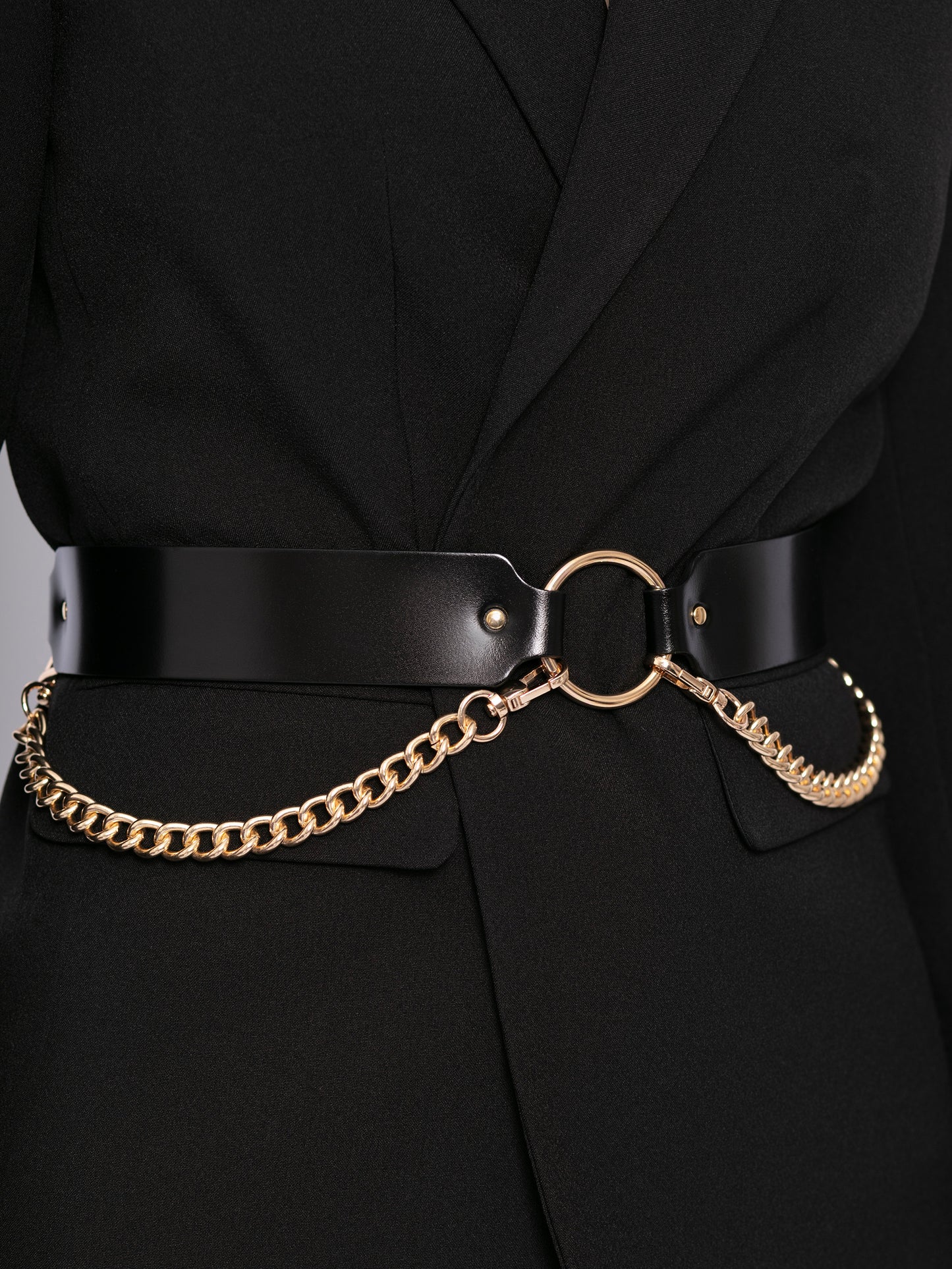 Close view of double chain leather belt worn over black blazer.