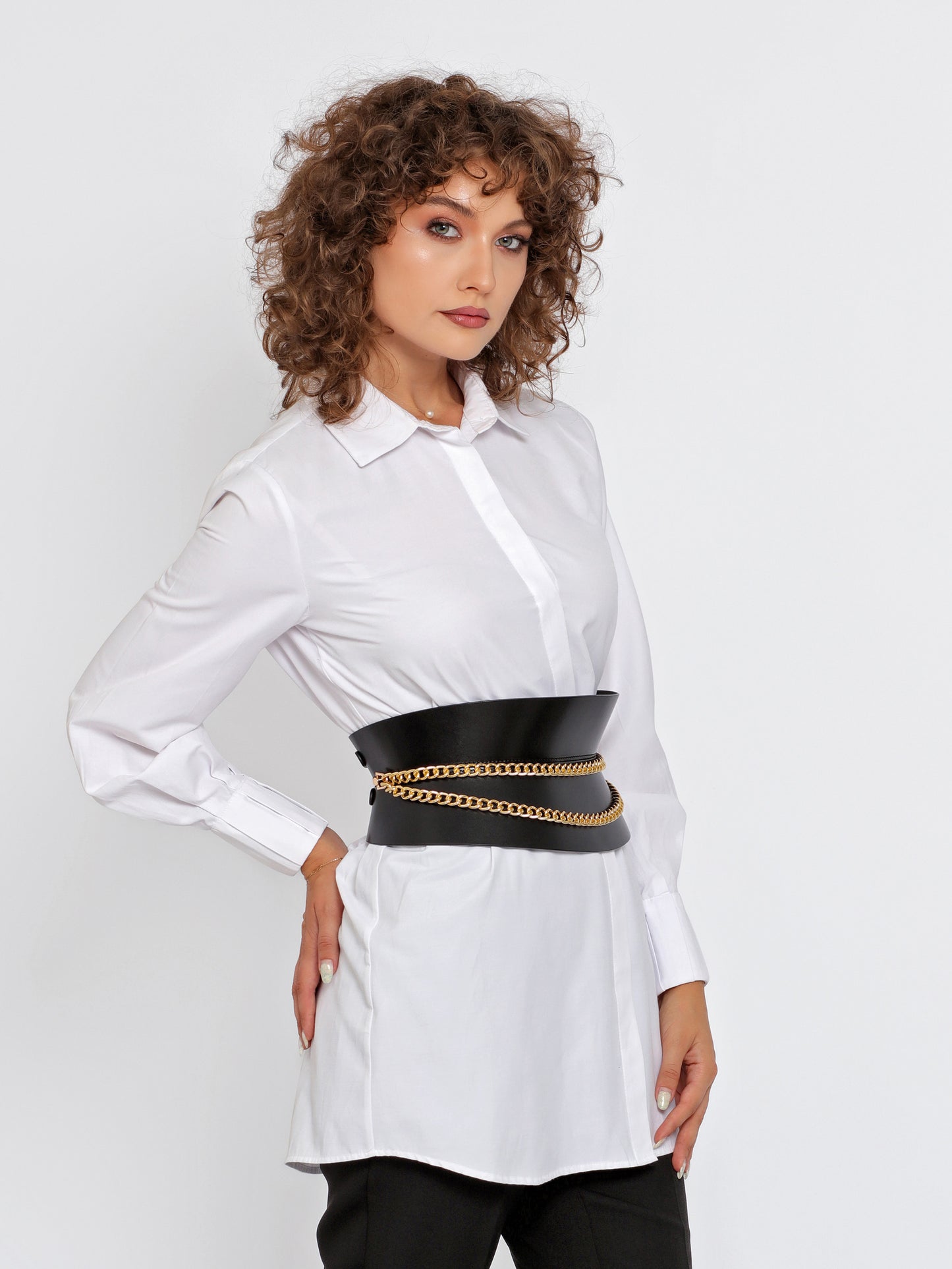 Side view of black hourglass corset belt being worn over white shirt.