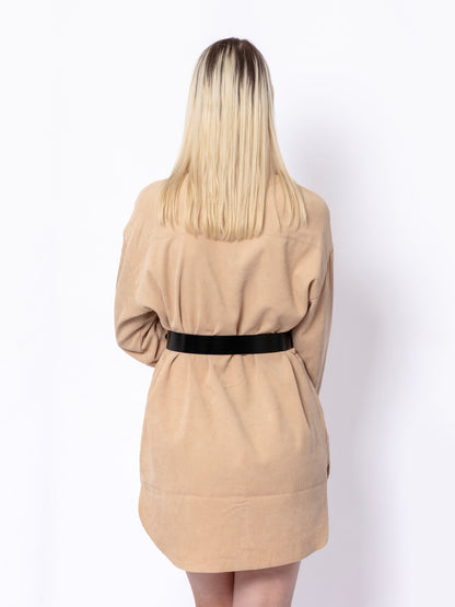 Back view of black leather belt worn over beige shirt.