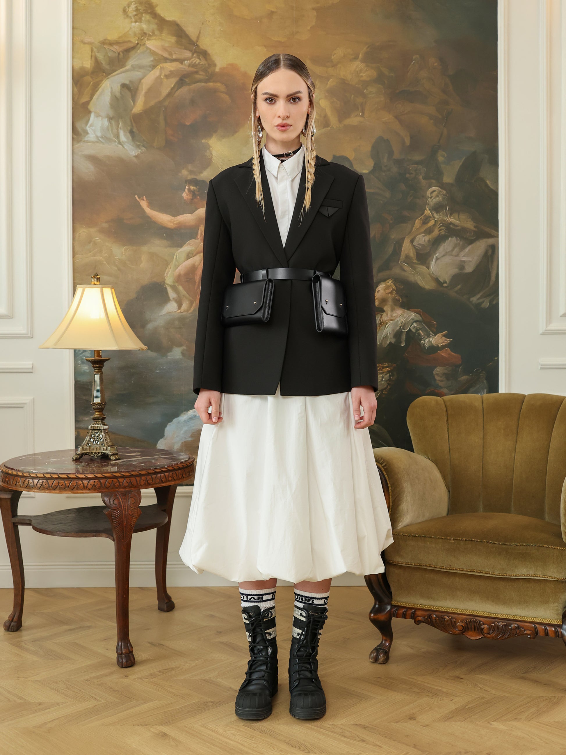 Black leather waist belt bag with double pouches worn over black blazer.