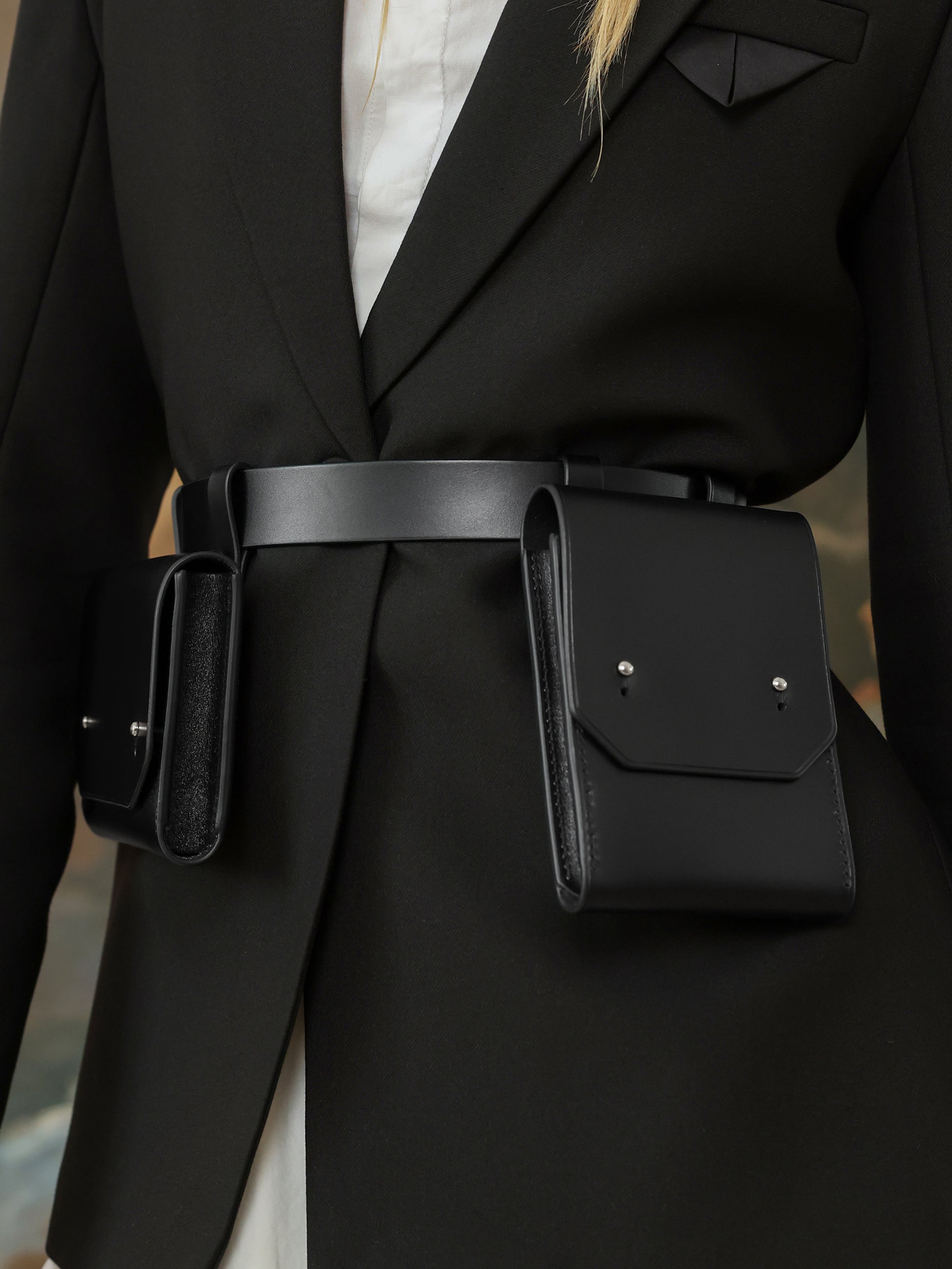 Close-up of black leather double pocket waist belt bag for women.