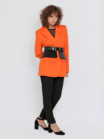 Full outfit view of black peplum leather belt being worn over orange blazer.