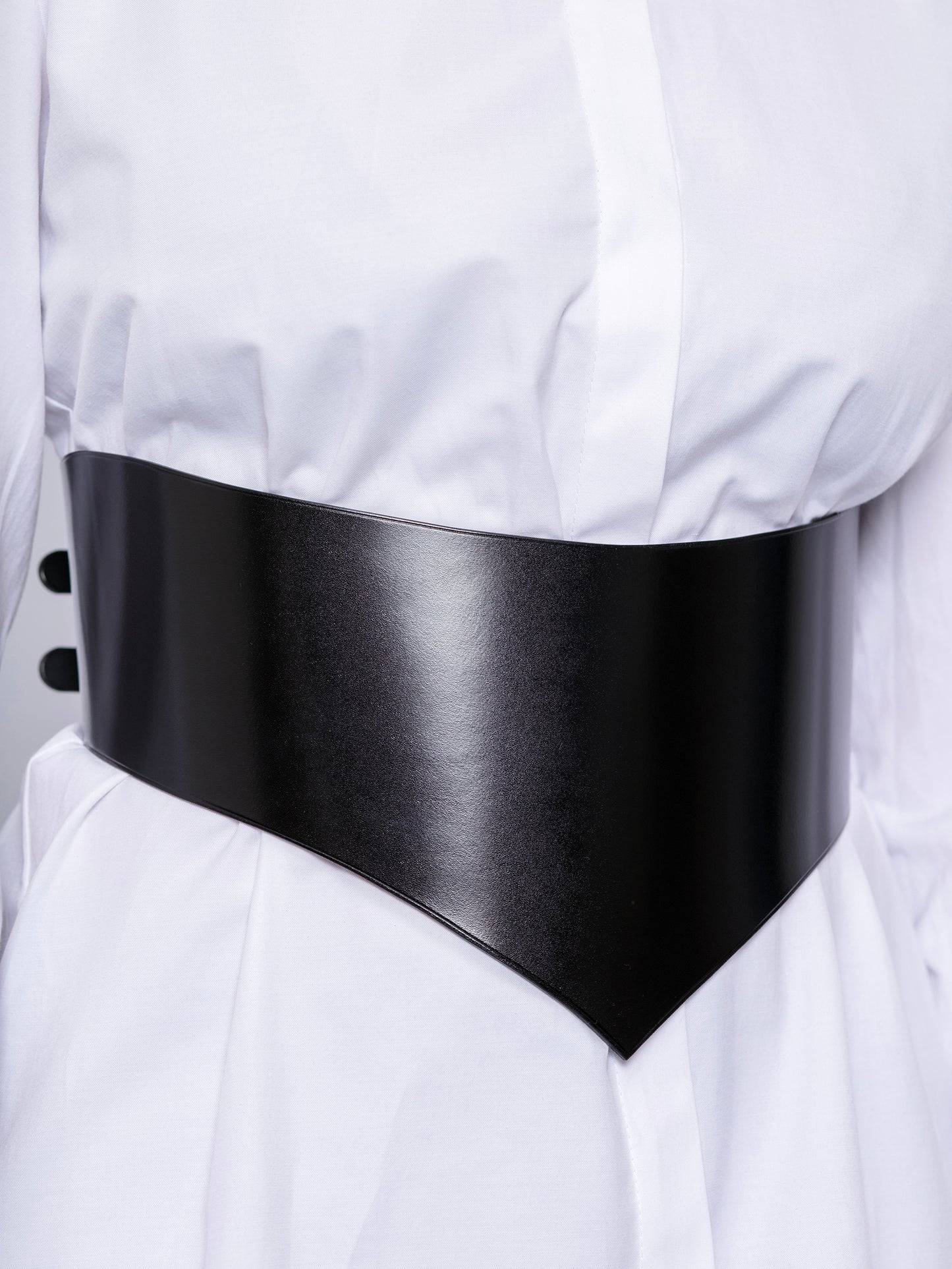 Close view of black wide leather belt. 