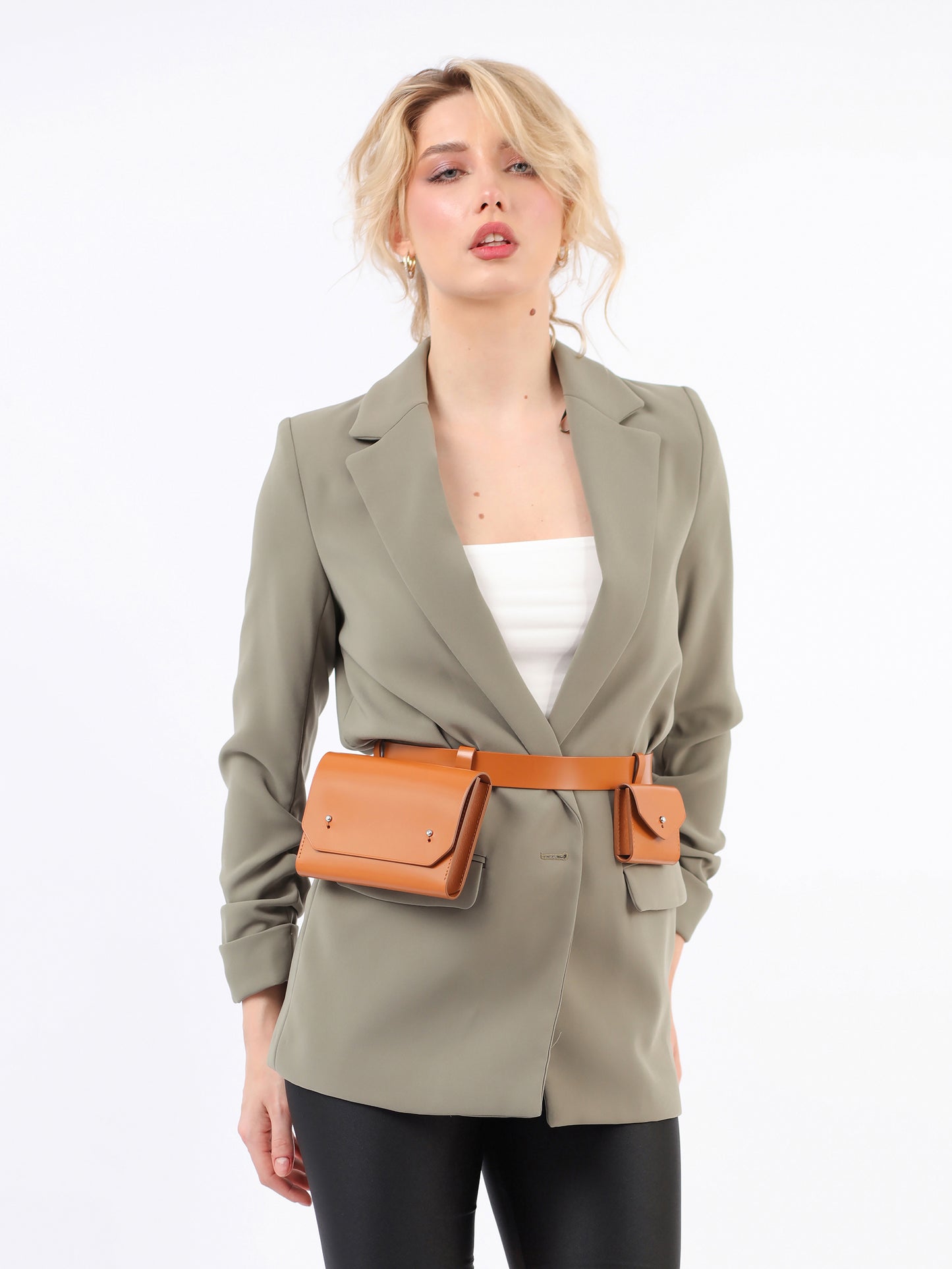 Brown double belt bag fitted on woman wearing green blazer.