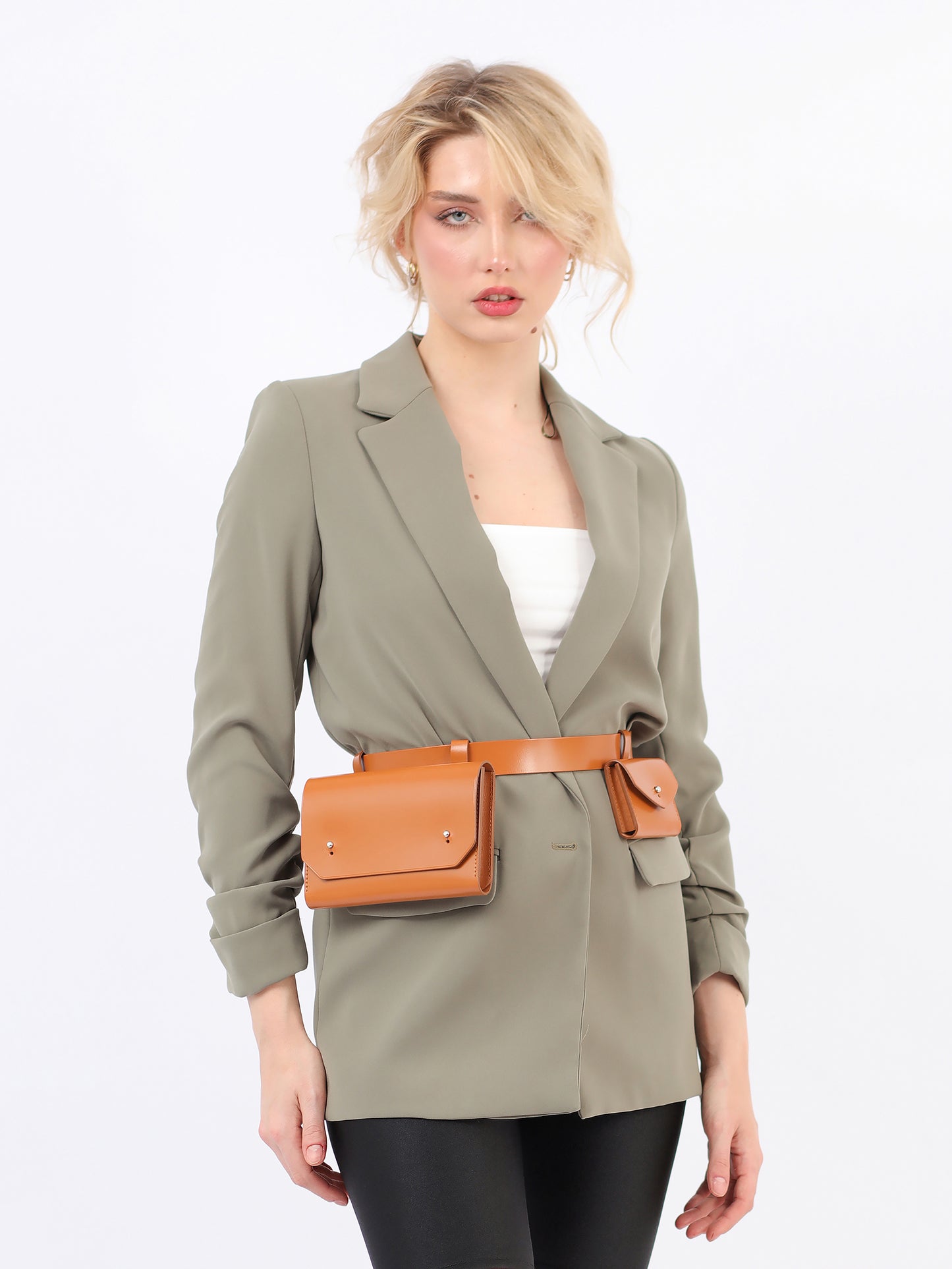 Brown double belt bag fitted on woman wearing green blazer.