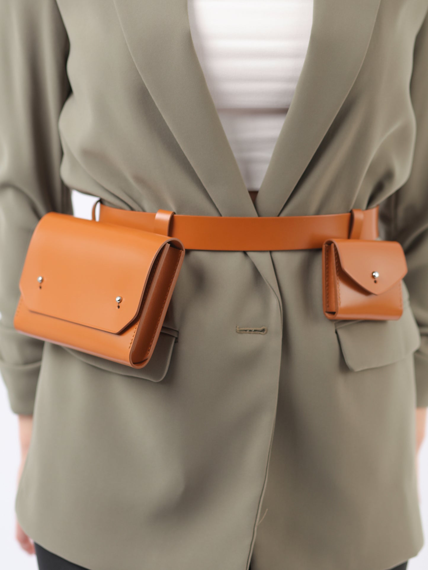 Detailed view of brown double belt bag. 