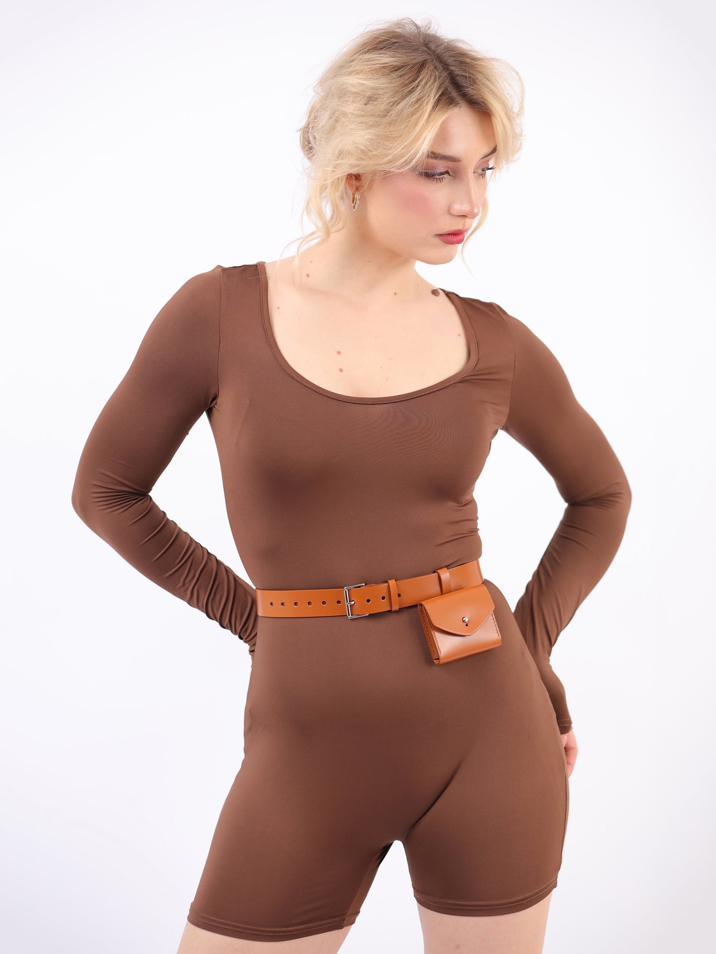 Brown micro belt bag fitted on woman wearing jumpsuit.