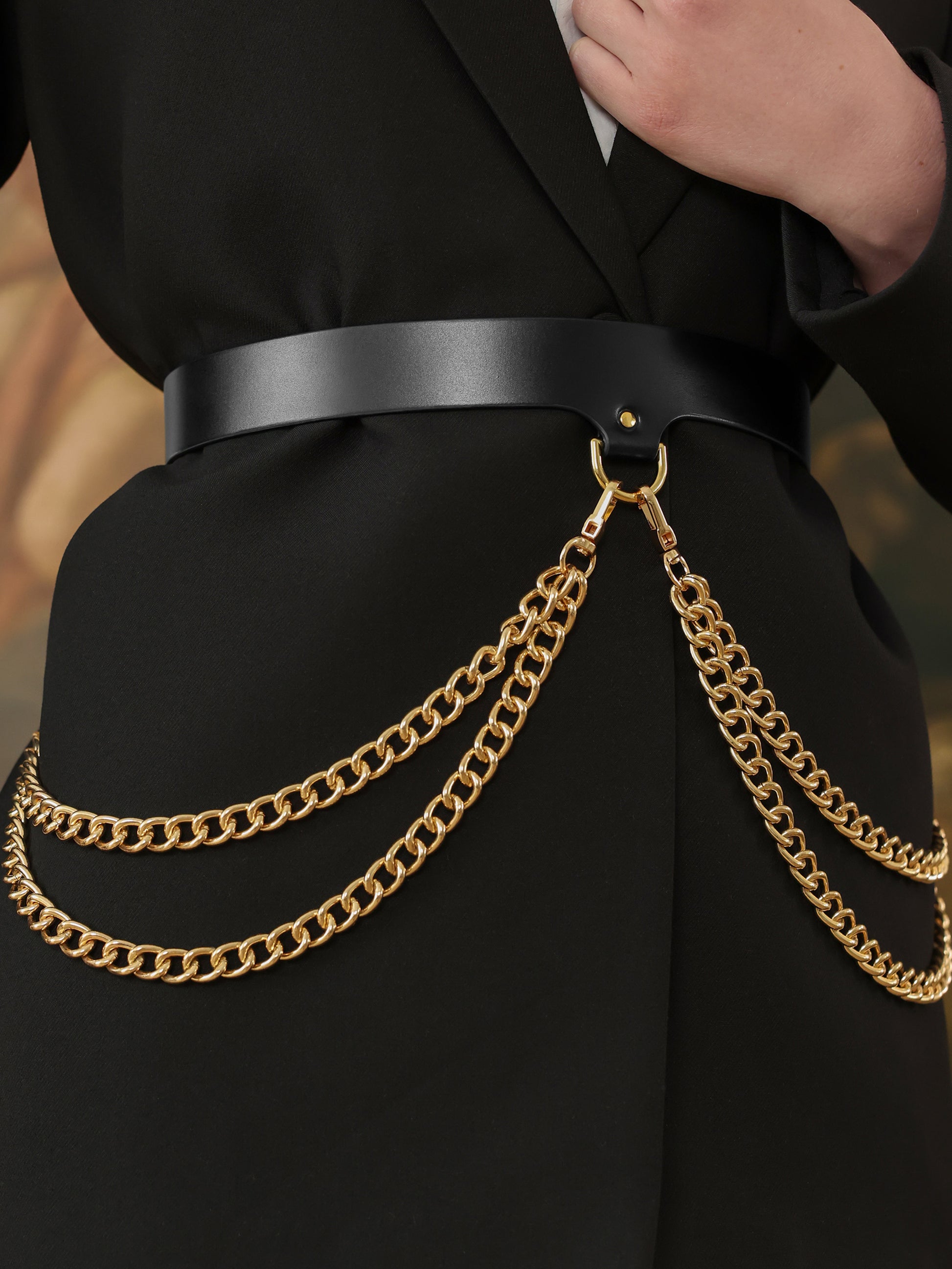 Close-up of black chain belt with layered gold chains for women.