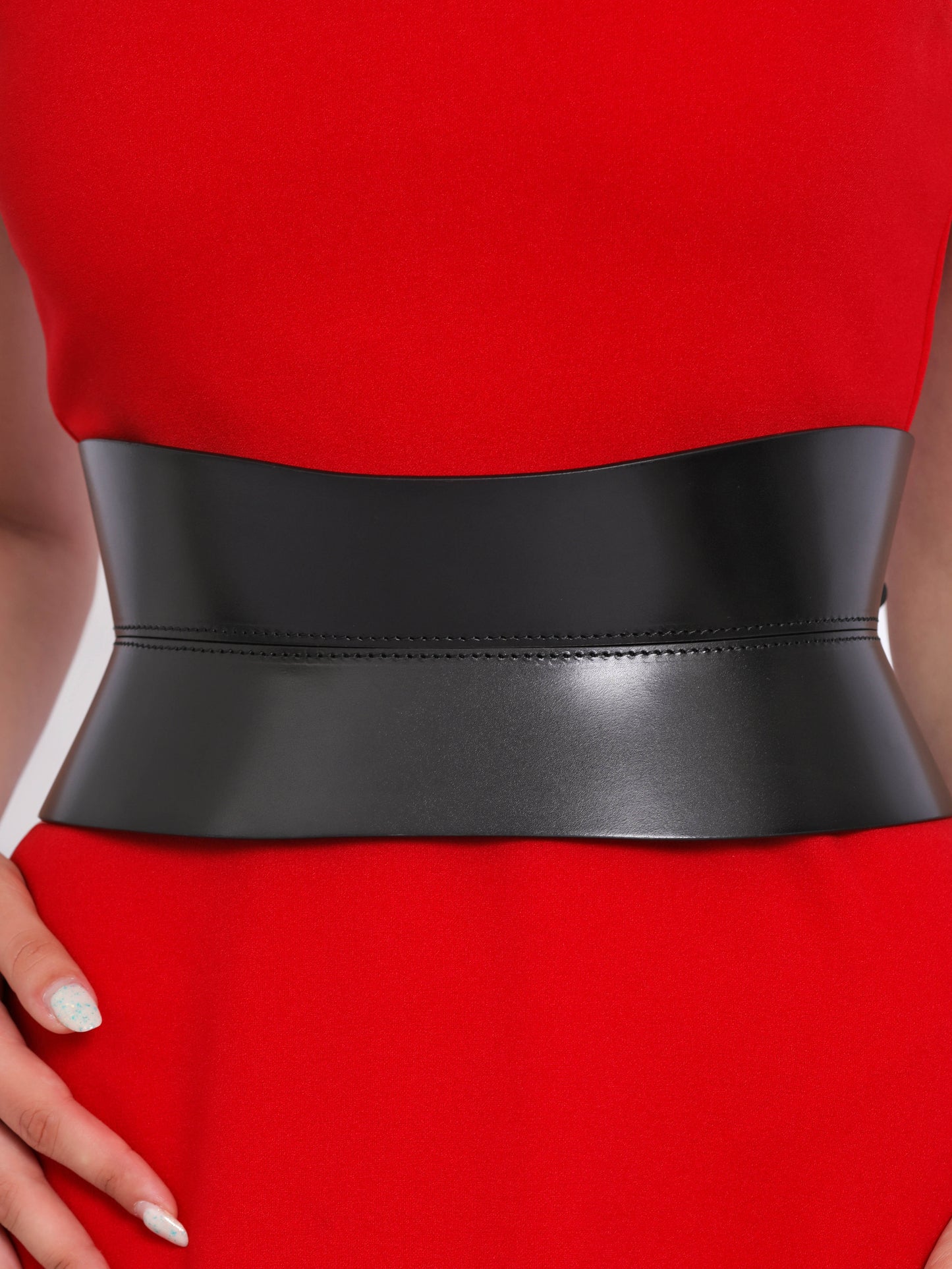 Close view of hourglass corset belt being worn over red dress.