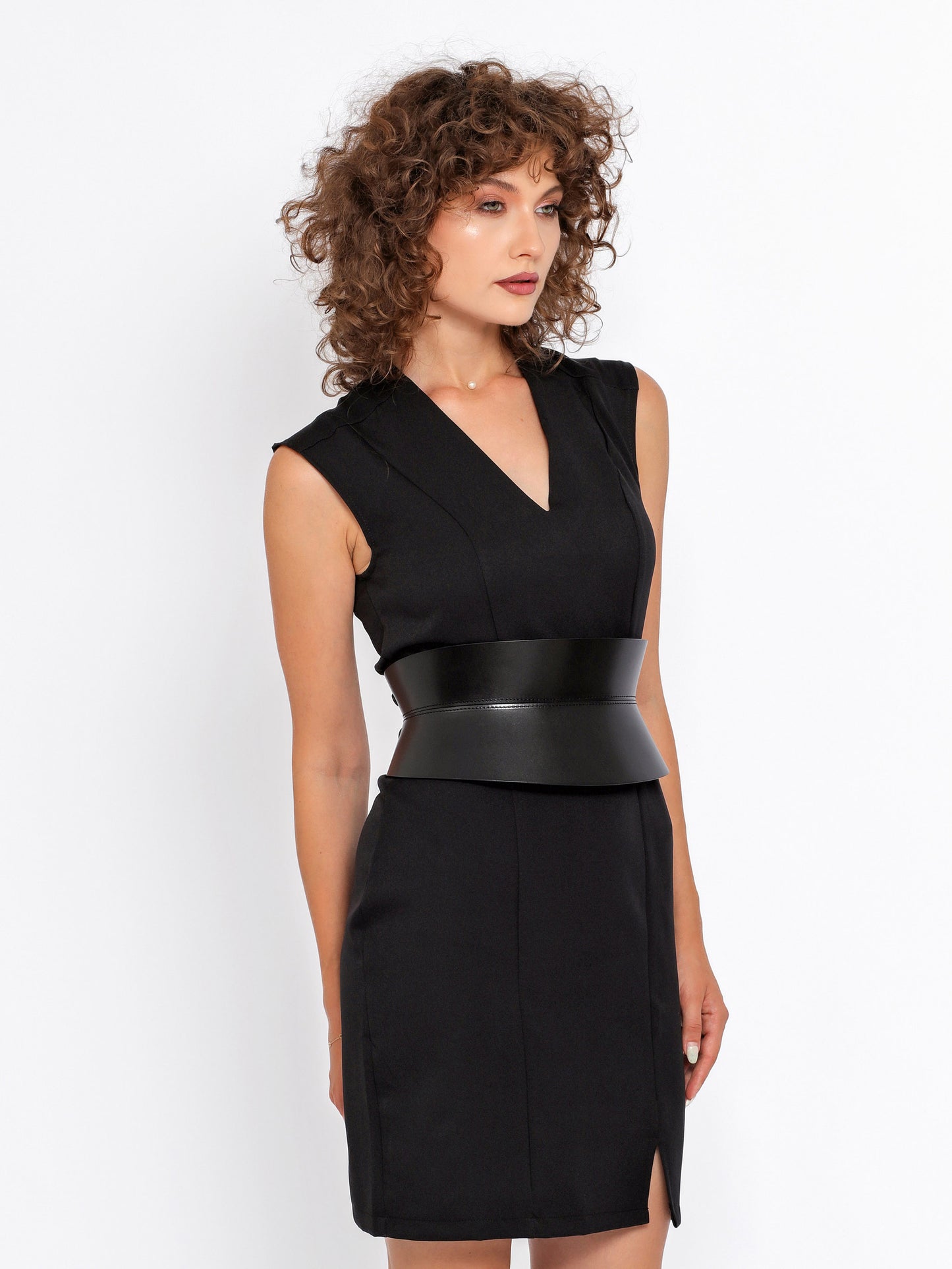 Side view of black hourglass belt being worn over black dress.