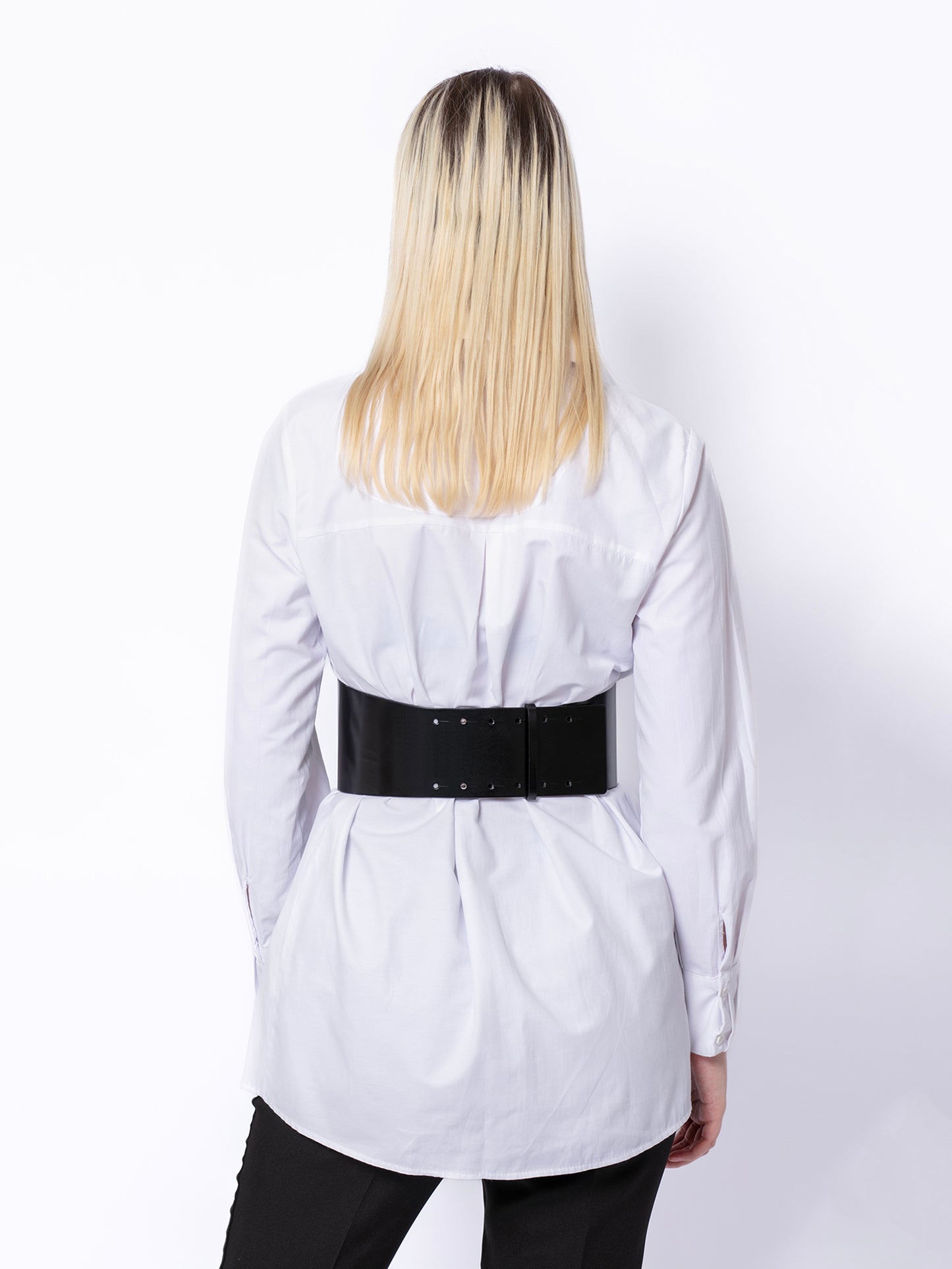 Back view of corset leather belt worn over white shirt.