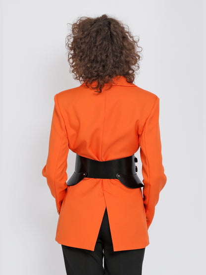 Back view of black leather peplum belt being worn over orange blazer.