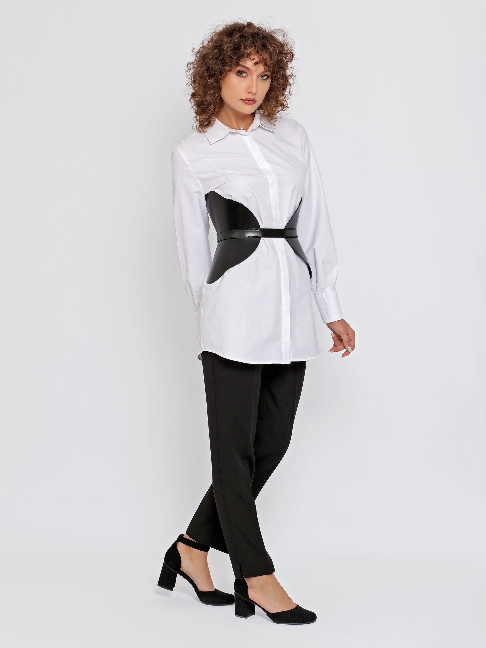Full outfit view of black wide leather belt worn over white shirt.