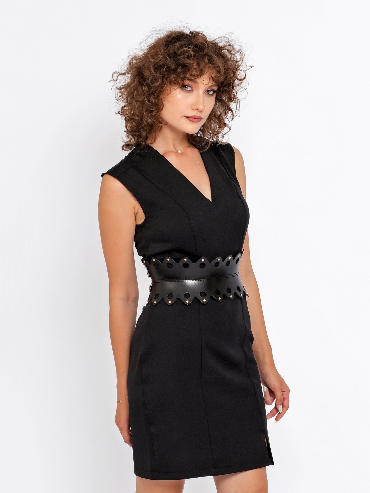 Side view of black hourglass belt being worn over black dress.