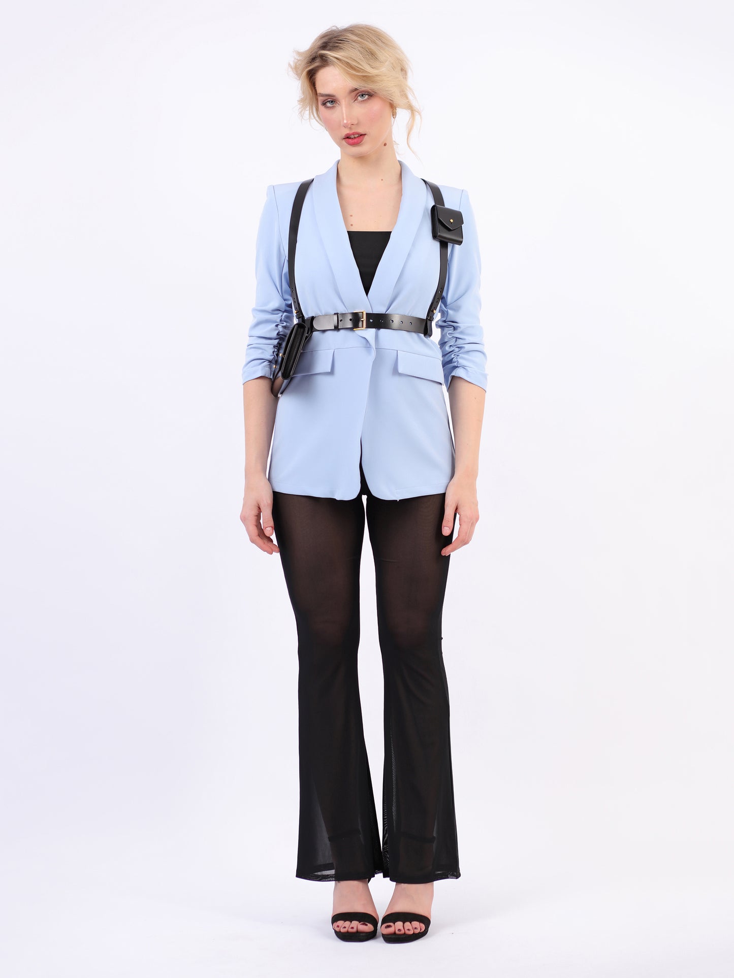 Black double bag harness fitted on woman wearing blue blazer and black trousers.