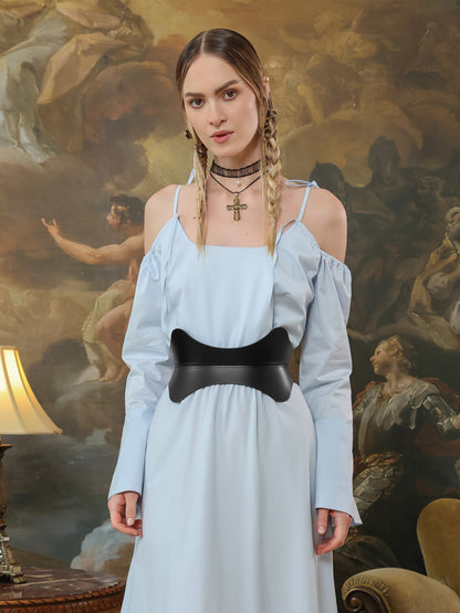 Elegant hourglass belt for women in black leather paired with a light blue cold-shoulder dress.