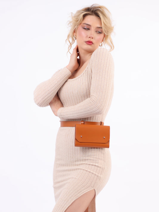 Leather envelope belt bag fitted on woman wearing cream dress.