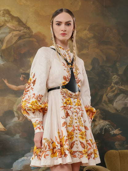 Woman in floral embroidered dress styled with leather chain harness.