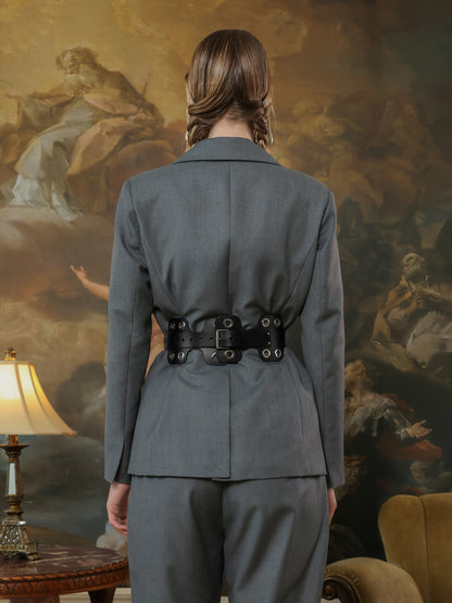 Back view of wide black leather belt with grommets styled on tailored suit.