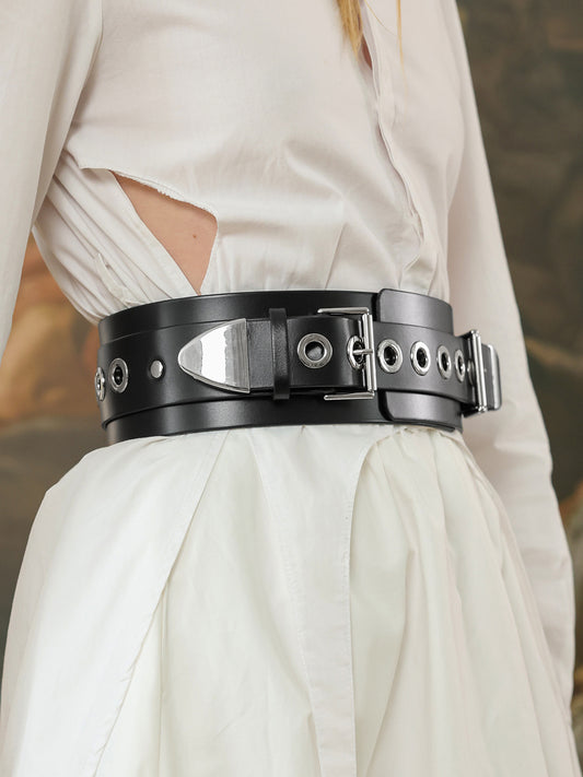 Close-up of black wide leather belt with eyelets and silver buckle.