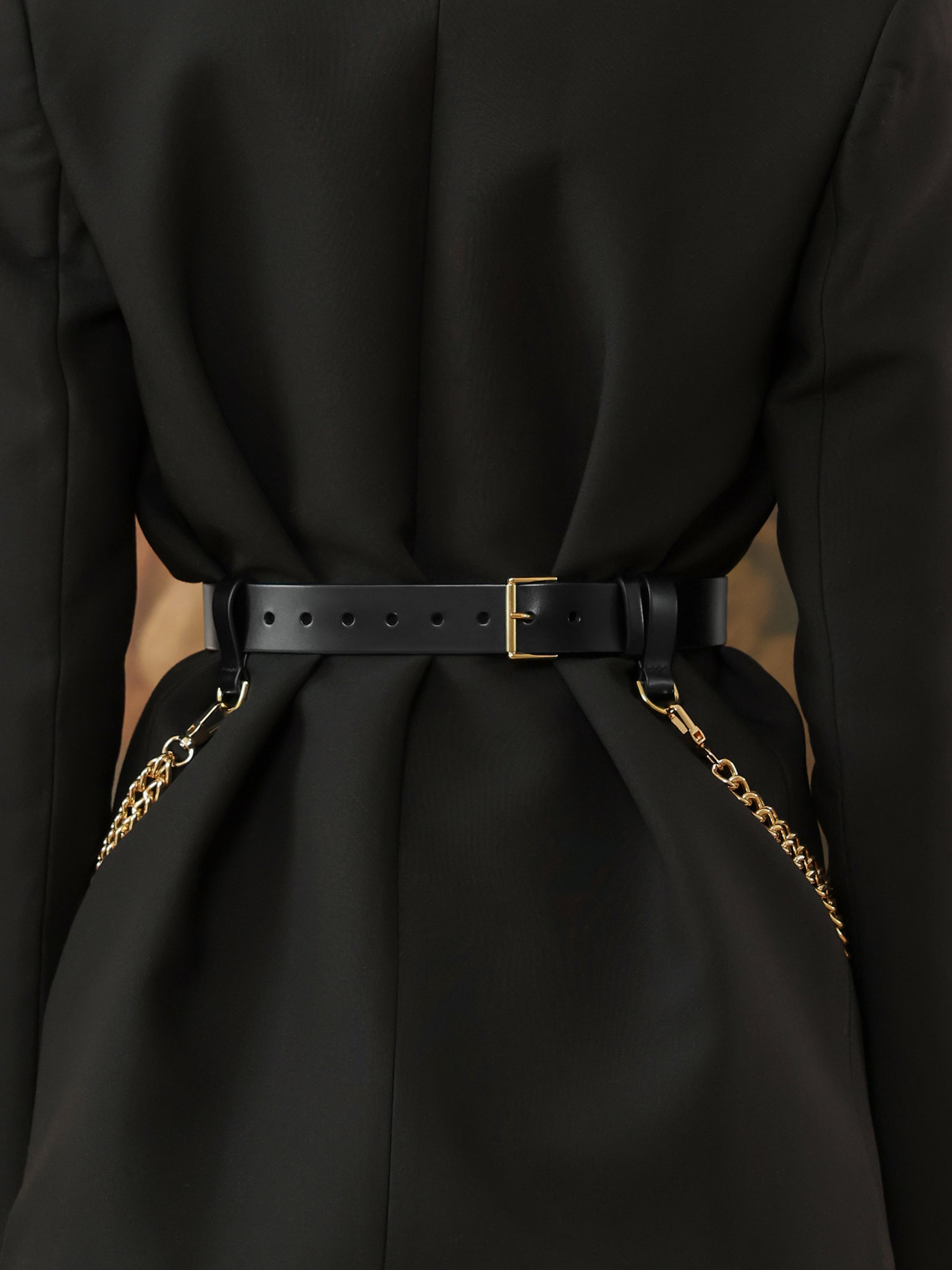 Back view of black leather waist belt with gold chain detail for women.