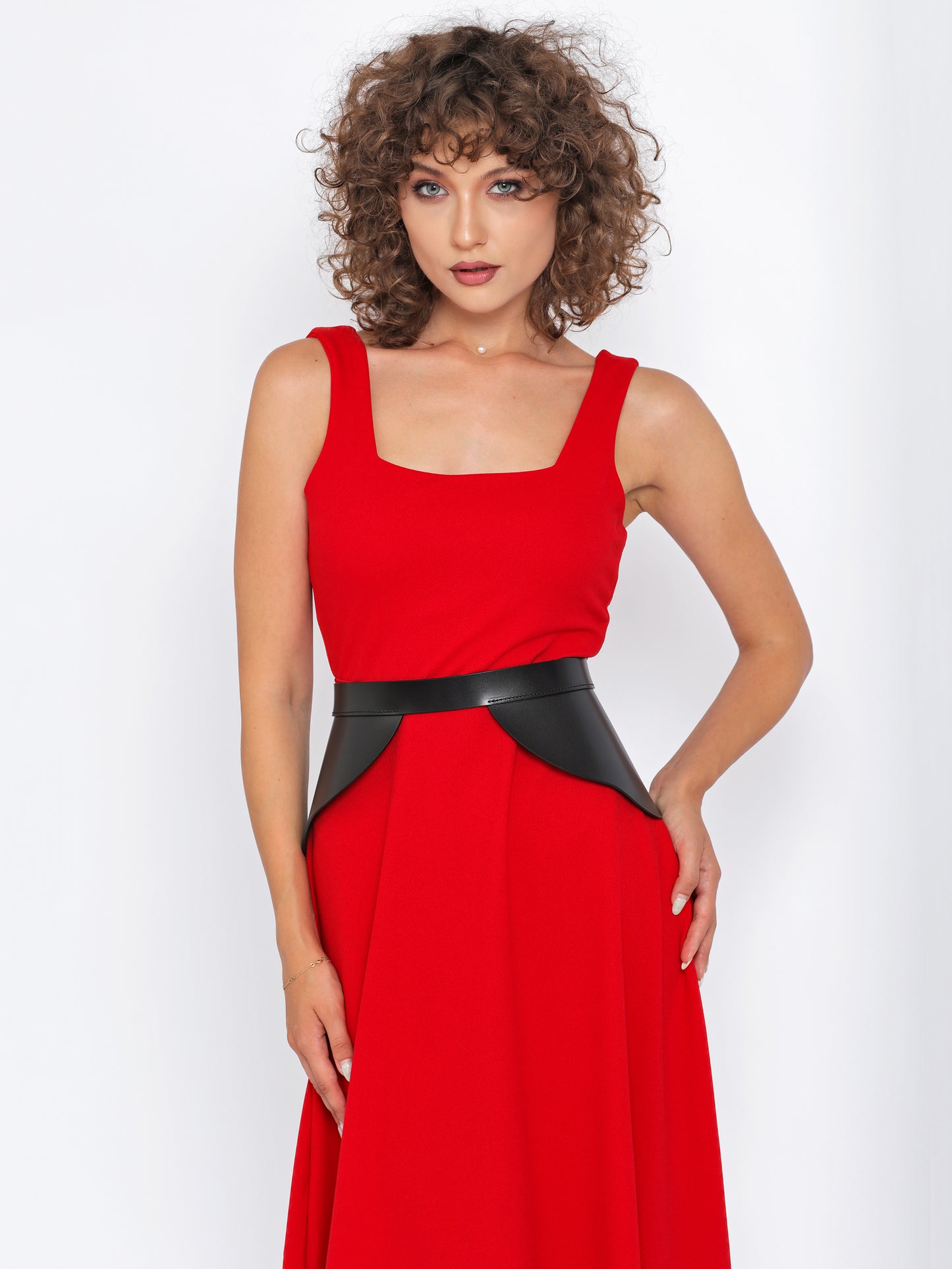 Front view of black leather peplum belt being worn over red dress.