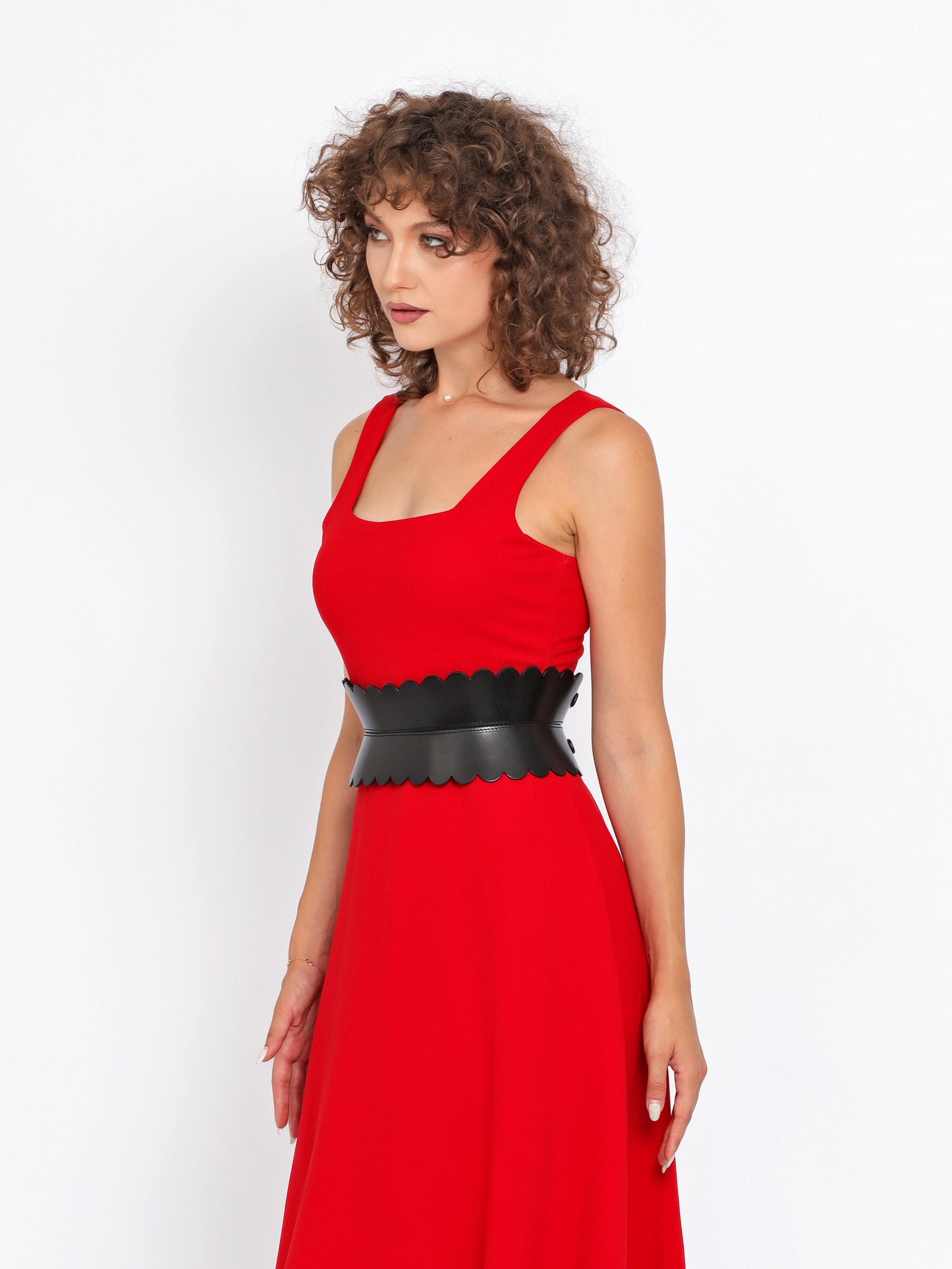 Side view of black hourglass belt being worn over red dress.