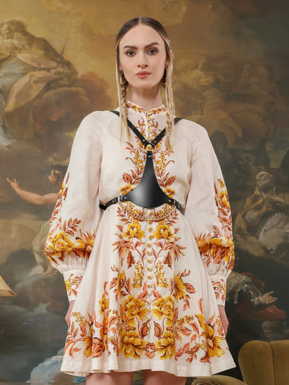 Fashion outfit featuring leather chest harness with gold chains for women.