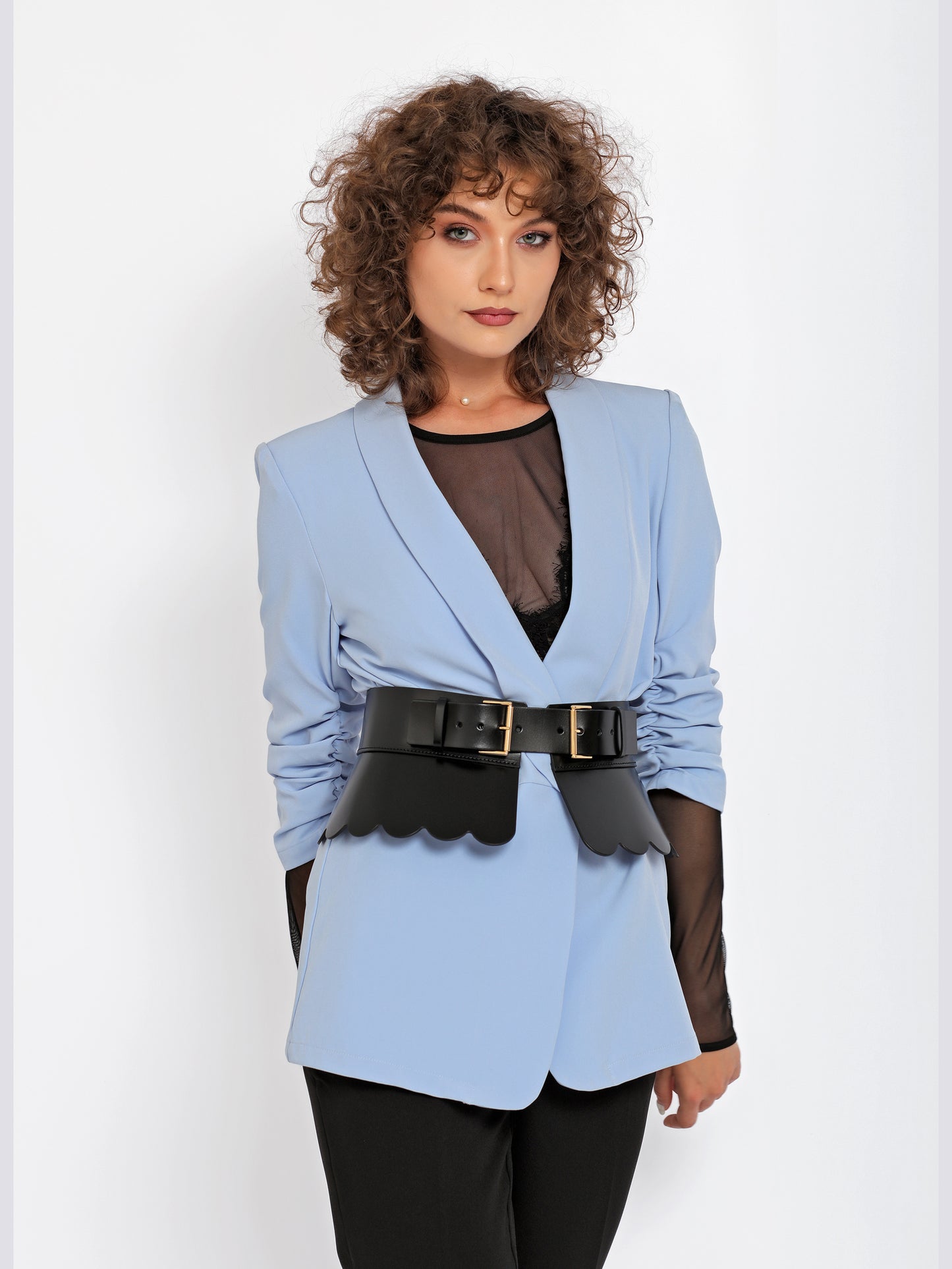 Front view of scalloped peplum belt being worn over blue blazer.