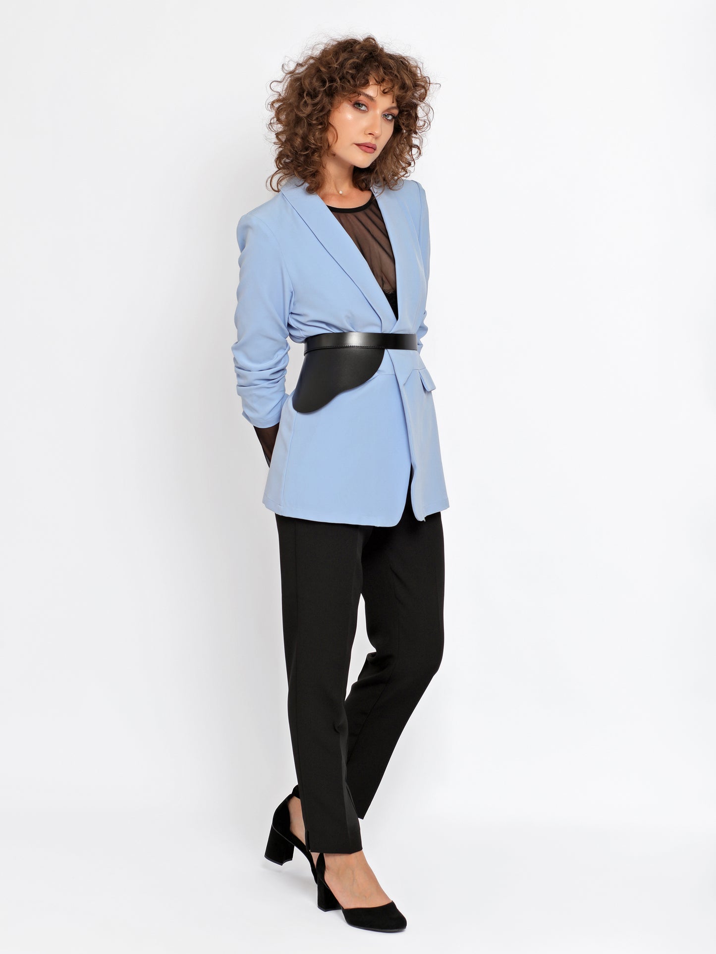 Outfit view of peplum leather belt being worn over blue blazer and black trousers.