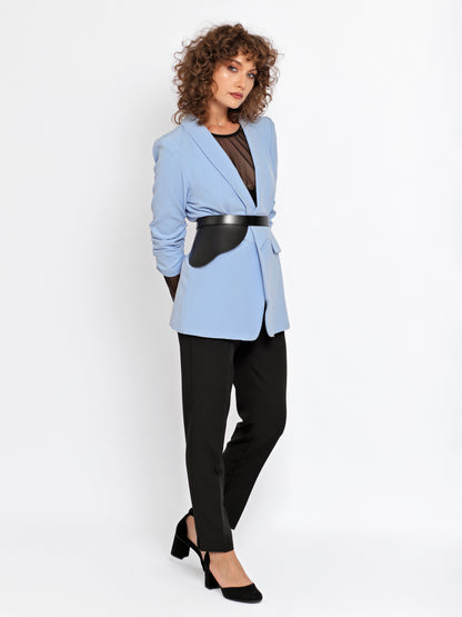 Outfit view of peplum leather belt being worn over blue blazer and black trousers.