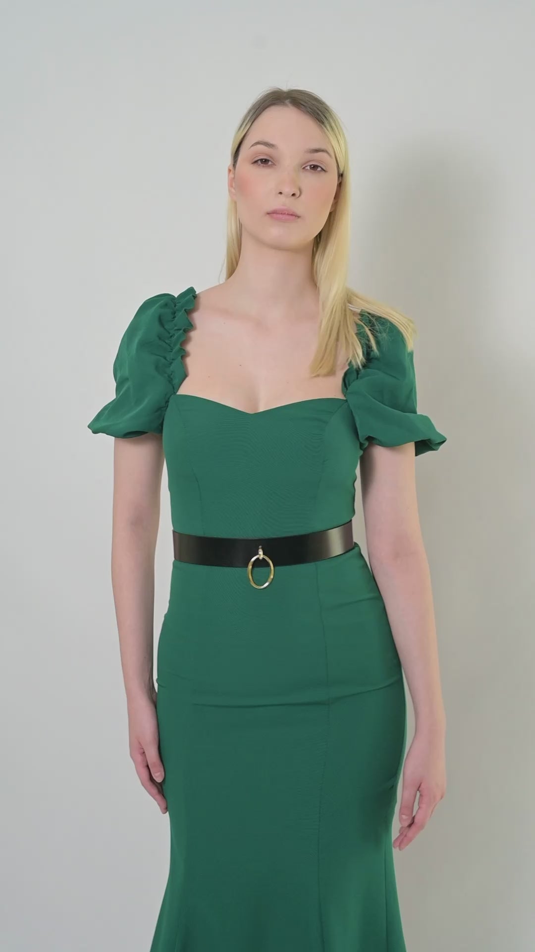 Video of high waist leather belt worn over green dress.