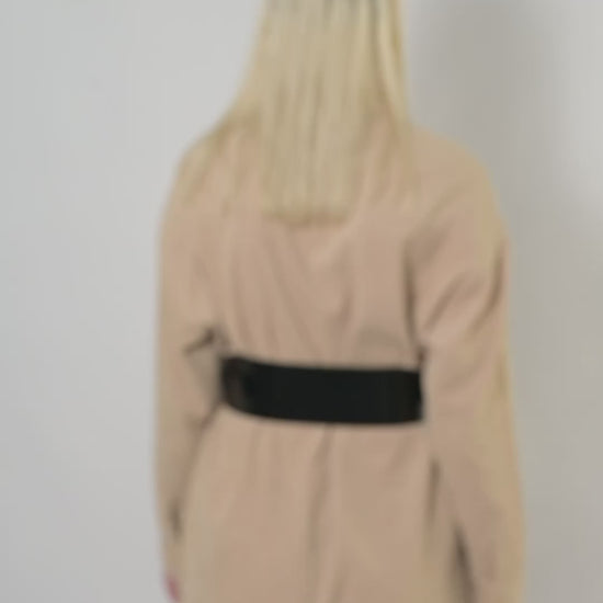 Video of black leather corset belt worn by model over beige shirt.