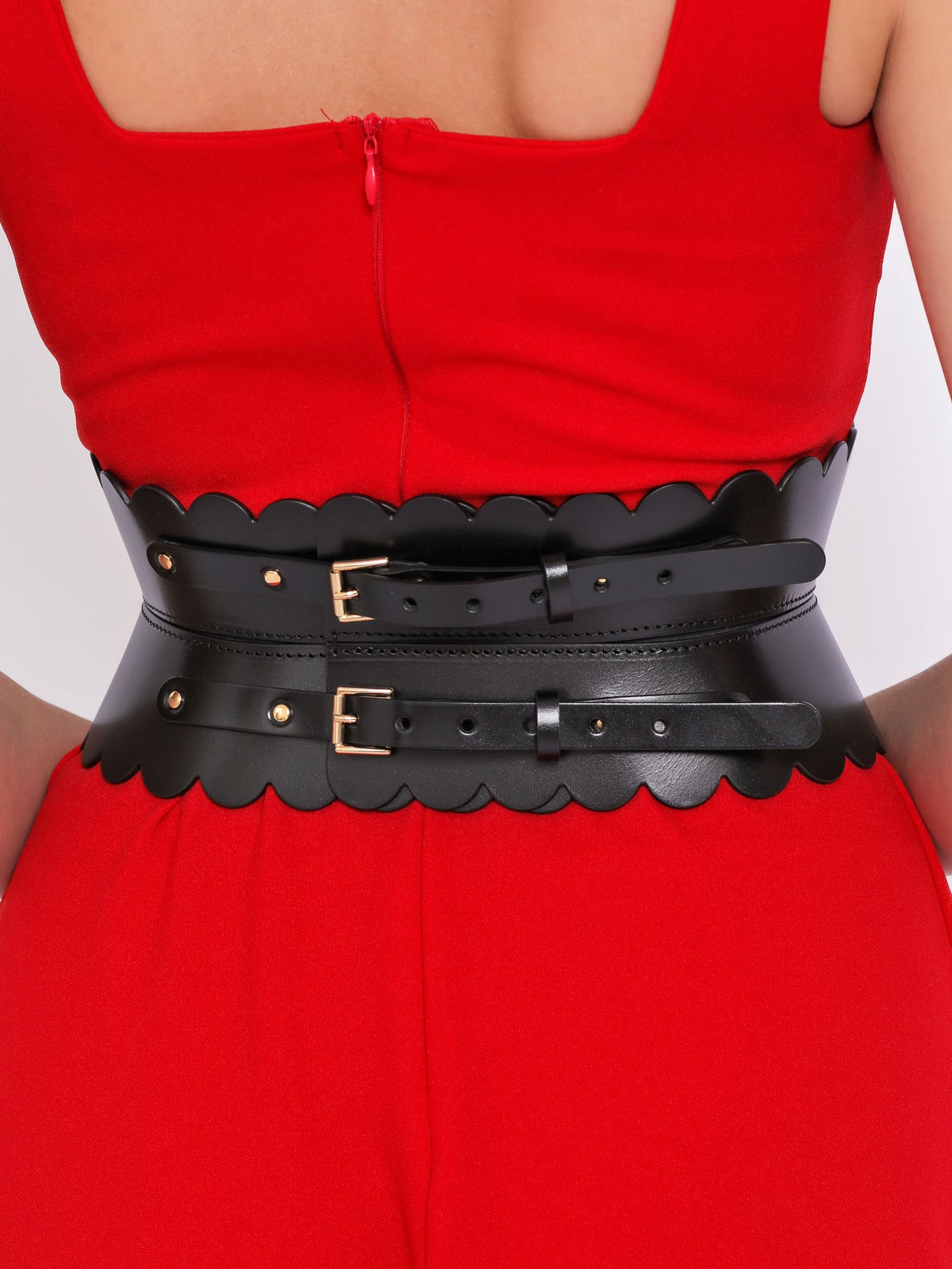 Back view of scalloped hourglass belt being worn over red dress.