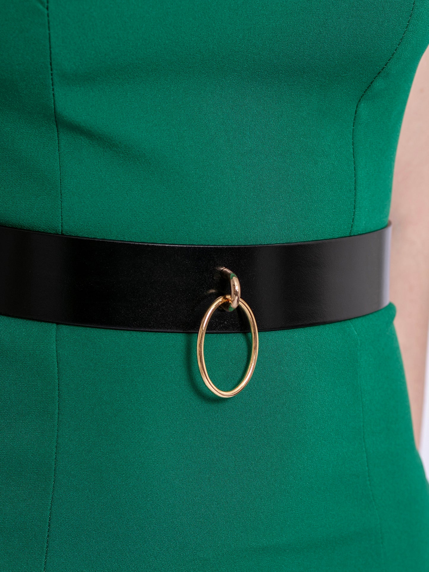 Close view of high waist leather belt worn over green dress.