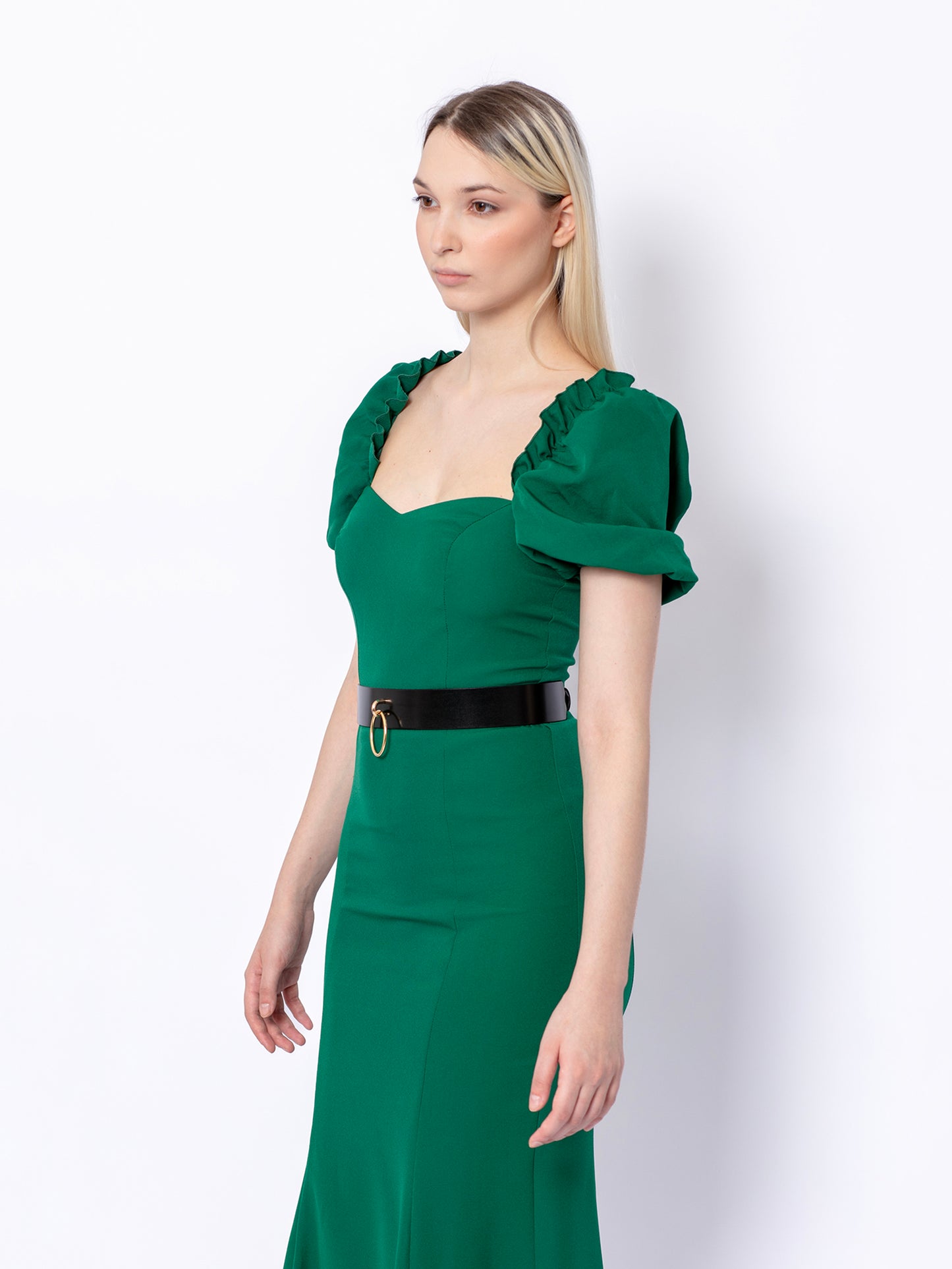 Side view of high waist leather belt worn over green dress.