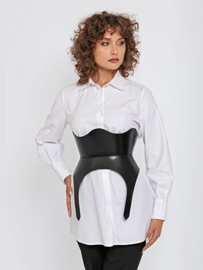 Detailed view of women corset belt worn by model over white shirt.