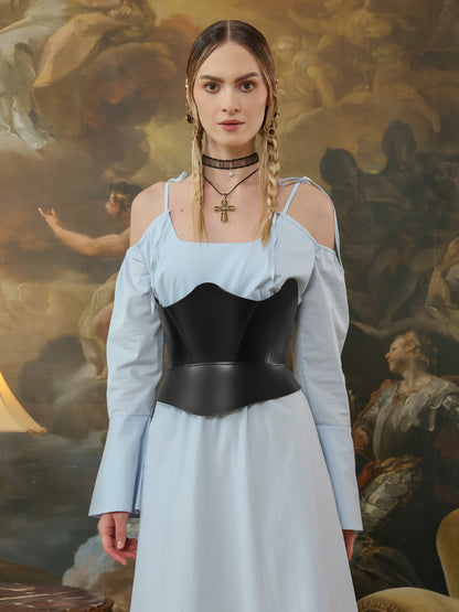 Front view of a black leather underbust corset belt paired with a blue cold shoulder dress.