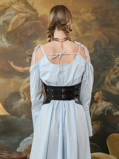 Back view of black underbust corset belt with double buckle straps over a light blue dress.