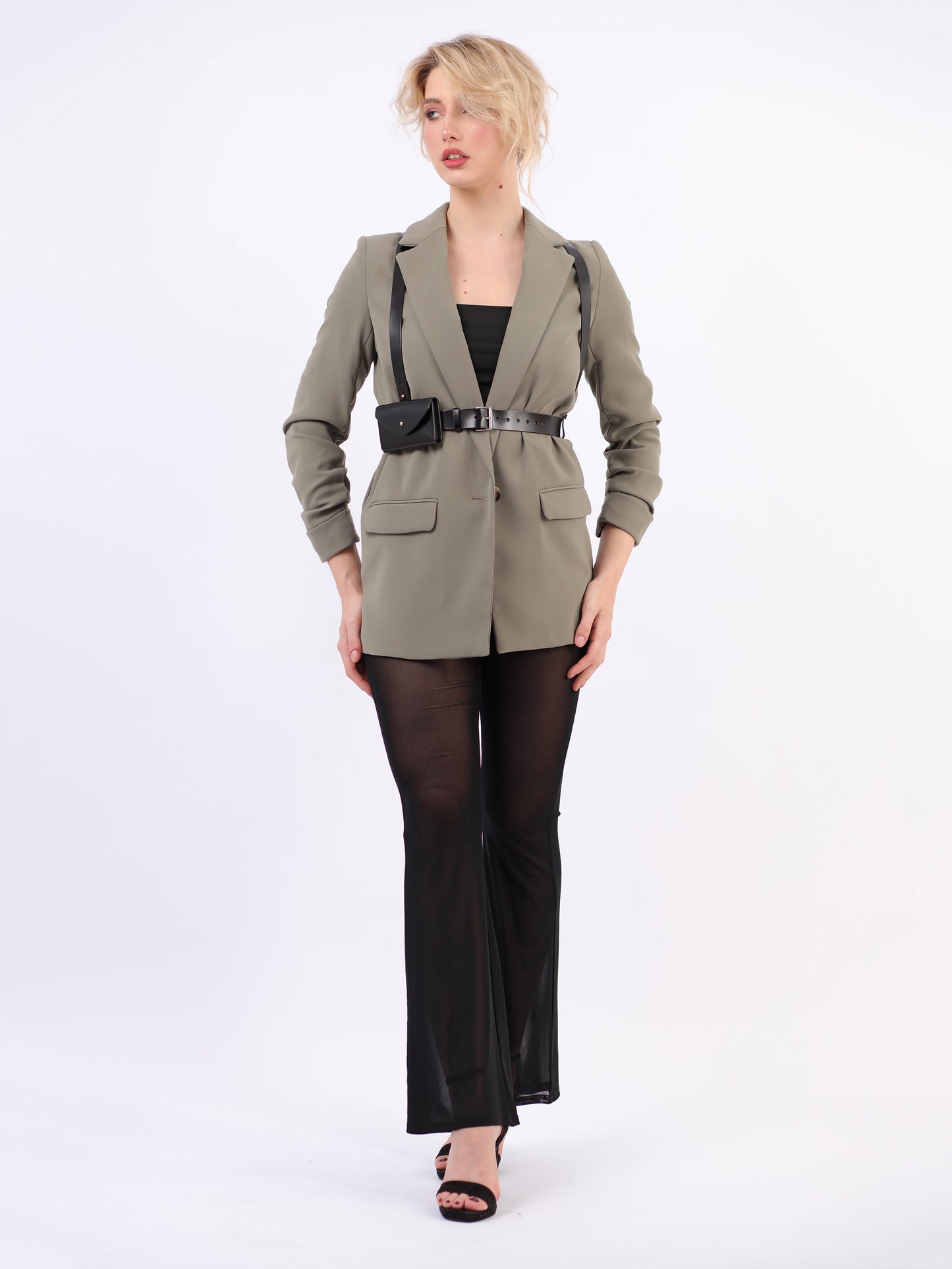 Black slim envelope harness fitted on woman wearing green blazer and black trousers.